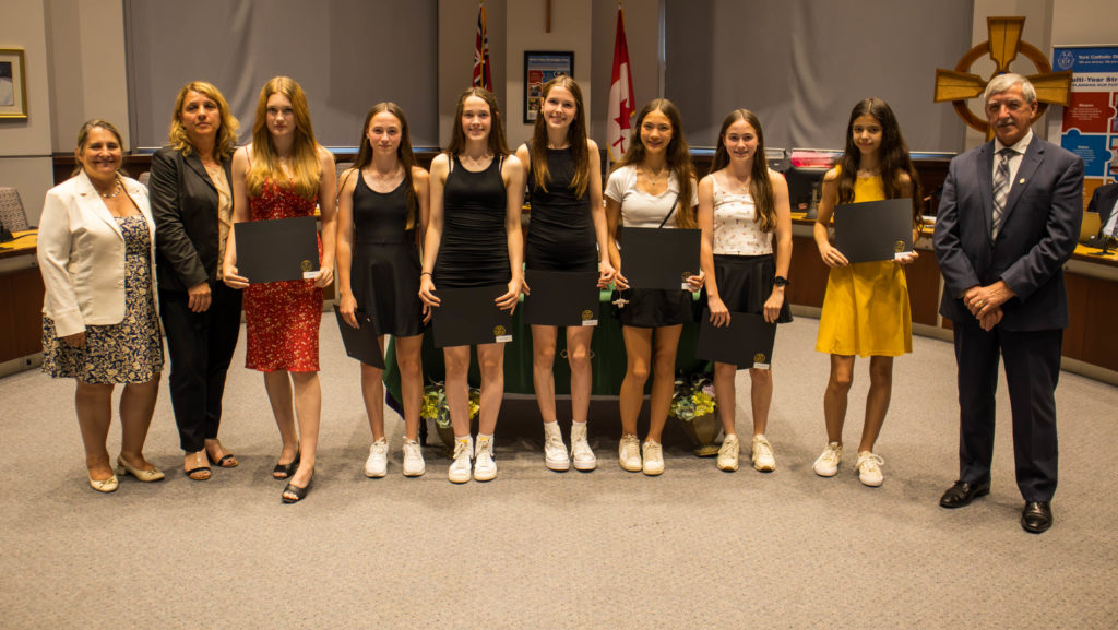 In picture: Kiara Silva, Fiona Marley, Keira Marley, Emmaleigh Sun, Bridget Malcolm and Grace Malcolm of the St. Maximilian Kolbe CHS Cross Country Team won a silver medal OFSAA. And Lilith Day of St. Maximilian Kolbe won a bronze medal for OFSAA Wrestling. Pictured in the YCDSB Boardroom with members of the Board of Trustees. 