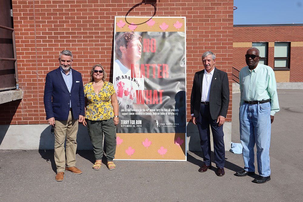 Minister of Municipal Affairs and Housing and MPP for Markham—Stouffville Paul Calandra, Chair of the Board of Trustees Elizabeth Crowe, , Interim Director of Education John De Faveri andTrustee for Area 2: Wards 4,5,7 & 8 (Milliken/Markham/Unionville) Frank Alexander stand next to a promotional banner for the Terry Fox Foundation.