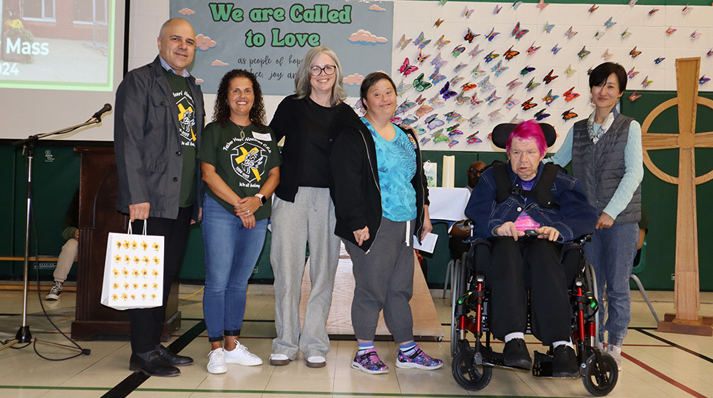 Catholic School Council Chair Lisa Balsamo presents members of L'Arche Daybreak with a donation to acknowledge their partnership