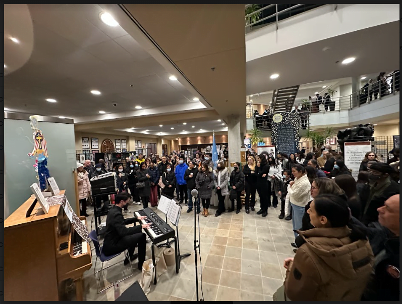 St Aug student playing piano in CEC lobby to crowd