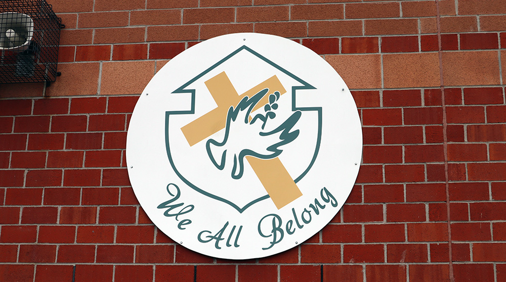 The Father Henri J.M. Nouwen CES crest with the motto "We All Belong"