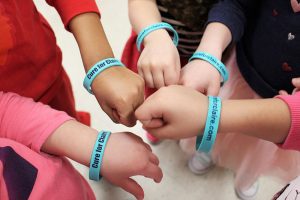 students at St. gabriel the Archangel school wearing bracelets that say "Cure for Claire"