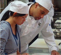 female student working with chef in kitchen