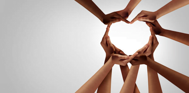 Hands of people from many races joining together to form a heart