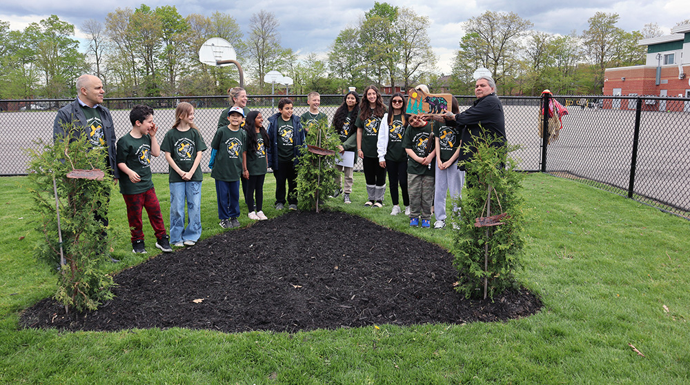Members of the school's land acknowledge writing team with the school's newly planted trees
