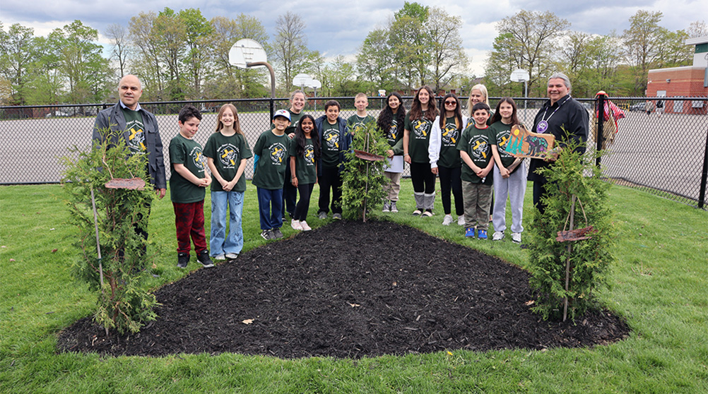 Members of the school's land acknowledge writing team with the school's newly planted trees