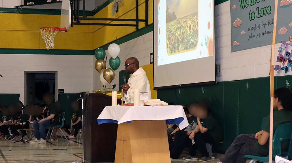 A priest celebrates Mass in the gym of Father Henri Nouwen CES