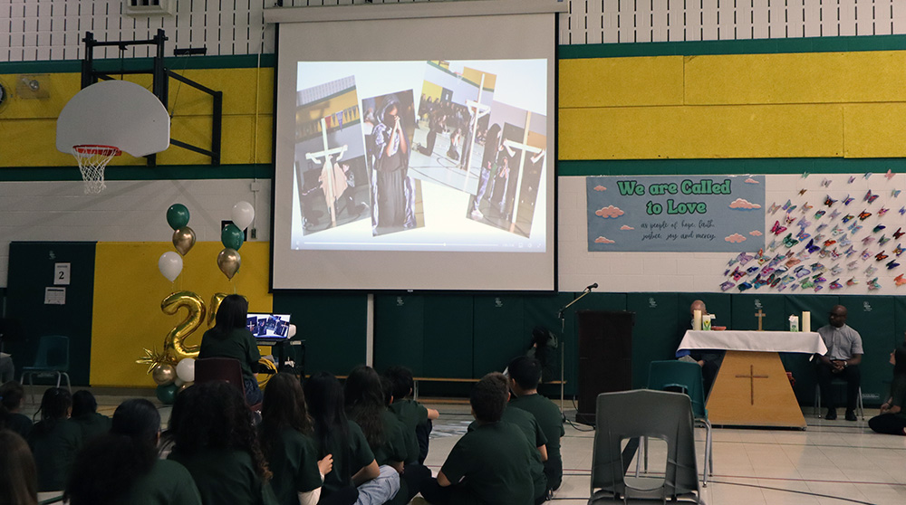 Students watch a slideshow of photos during their anniversary celebration