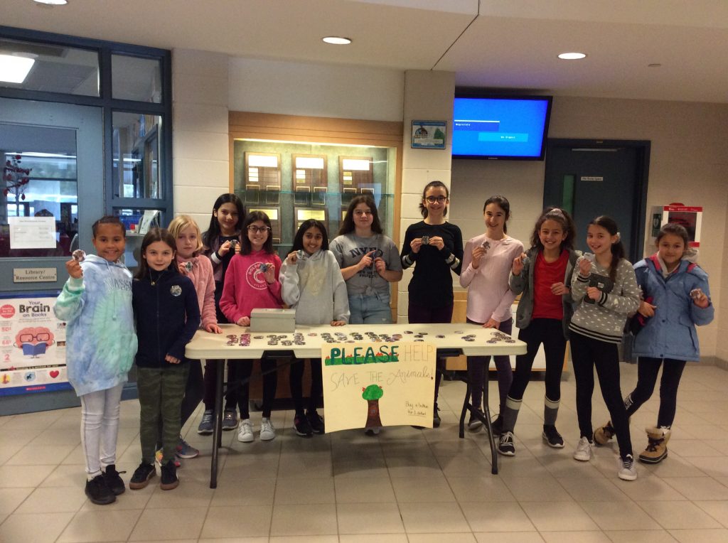 the eco team poses with their buttons at the sales table